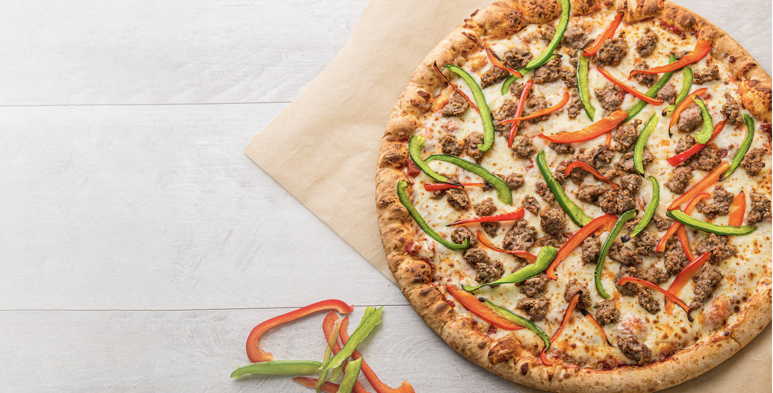 Pizza topped with sausage and red and green peppers