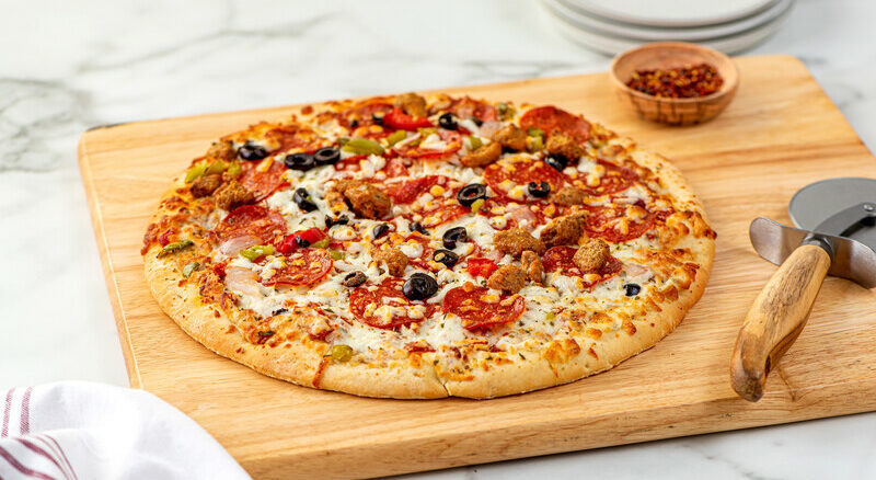 Supreme pizza on a cutting board