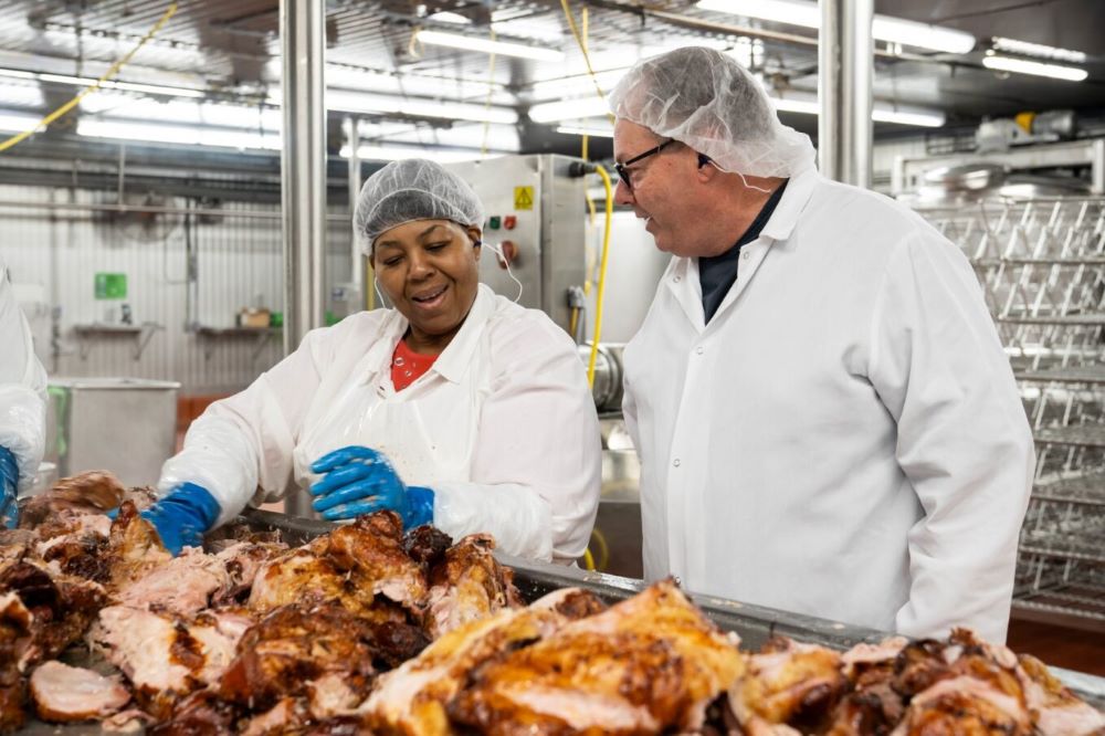 two workers in a bbq preparation plant