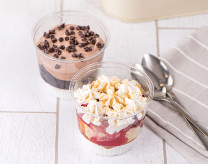 two parfaits on a table with spoons