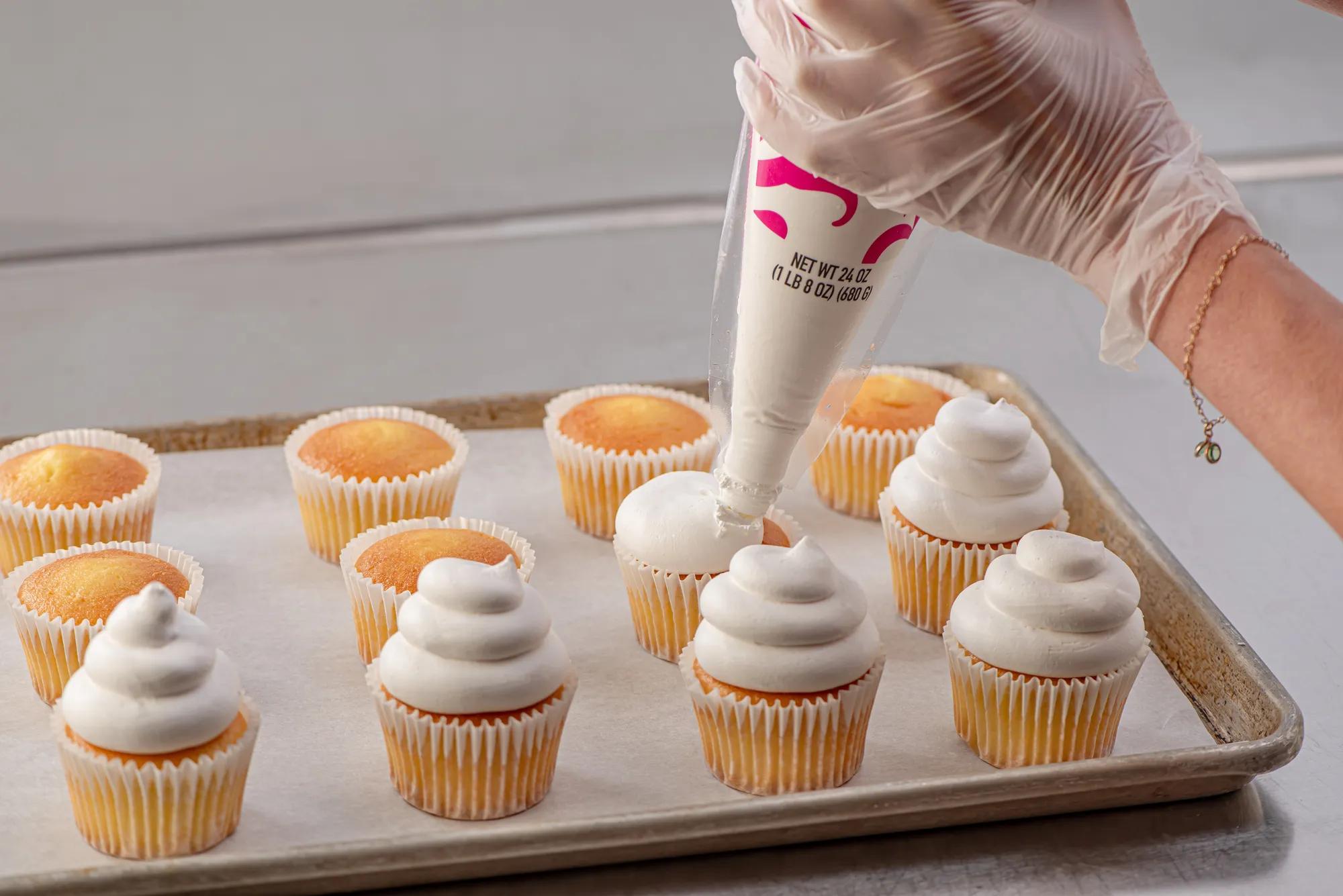 Hand piping icing on cupcakes