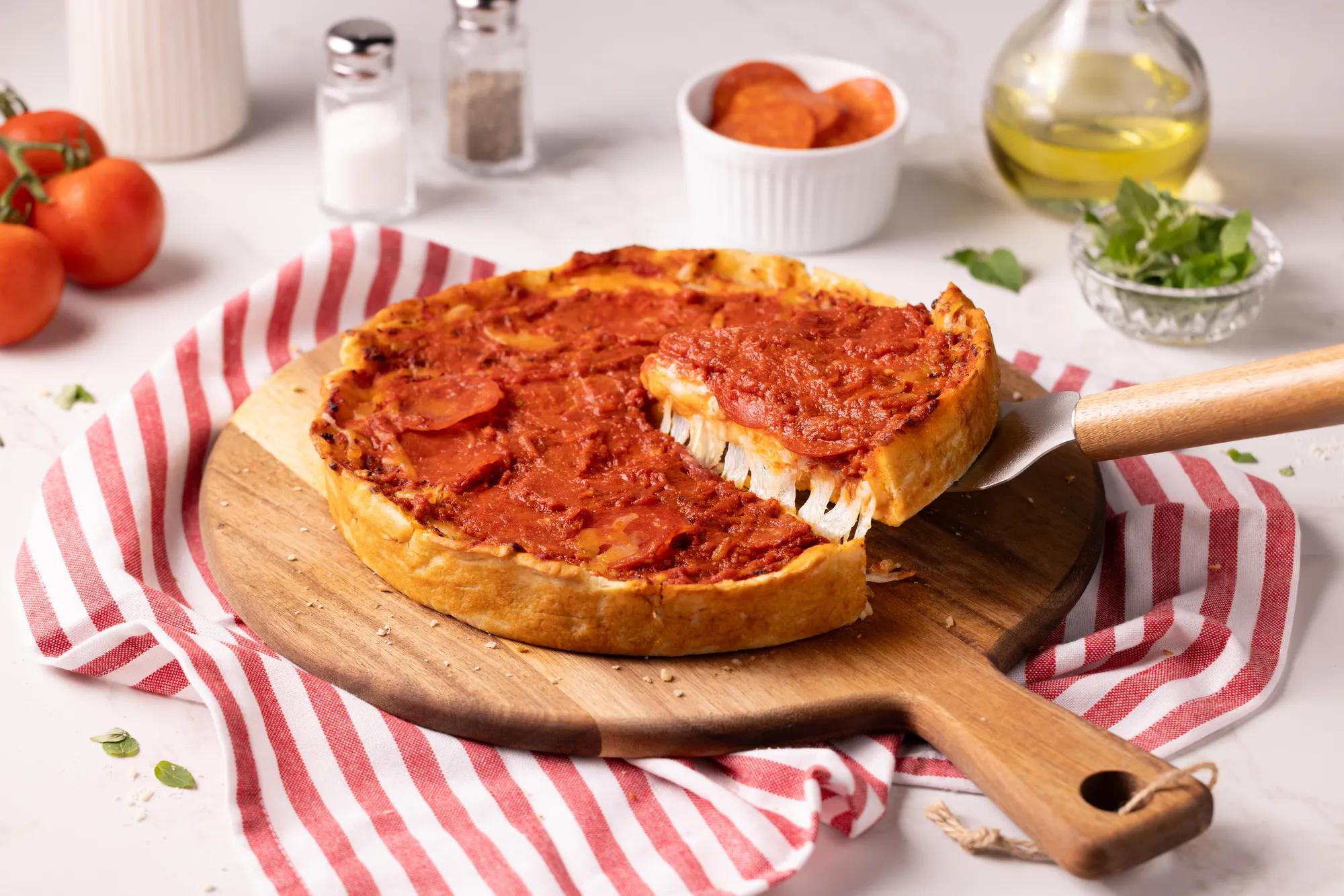 Deep dish pizza on a red and white striped towel